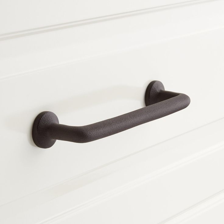 a black handle on a white cabinet door