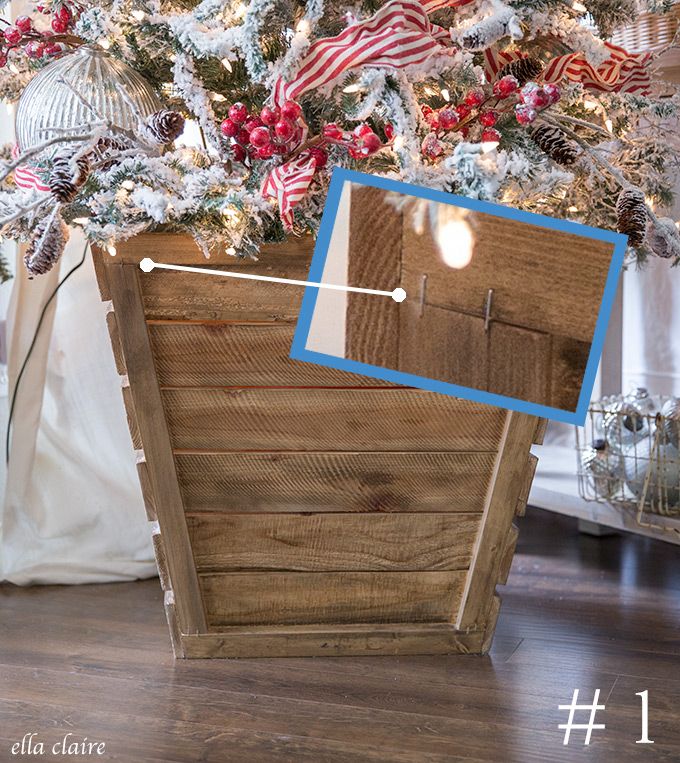 a christmas tree is decorated with red, white and blue ribbons in a wooden crate