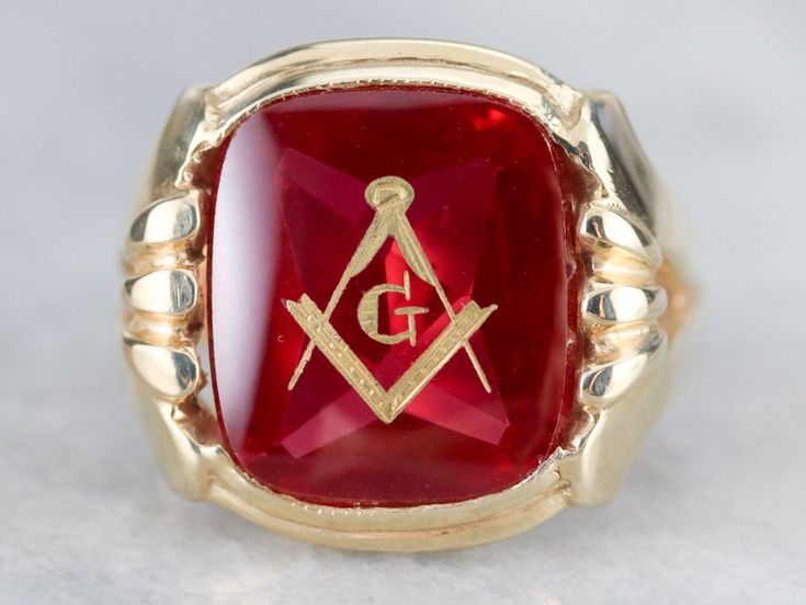 "This large vintage red glass Masonic ring has amazing, yet simply detailed shoulders, rising up from the shank and bending around the corners of the stone. The center is a classic red glass cabochon, inlaid with the gold Masonic symbol, with a nice flat profile. This ring has a substantial feel to it, and makes for a classic Masonic piece! Metal: 14K Yellow Gold Gem: Red Glass Cabochon, Gold Inlaid Masonic Symbol Gem Measures: 16mm x 14mm, Square Cushion Cut Size of Ring: 10 Marks: \"14K\" and Collectible Red Rings With Polished Finish, Heirloom Red Signet Ring With Polished Finish, Classic Red Signet Ring For Formal Occasions, Classic Red Engraved Jewelry, Collectible Red Engraved Ring, Red Engraved Signet Ring For Formal Occasion, Classic Red Intaglio Jewelry, Formal Red Engraved Signet Ring, Heirloom Red Ruby Cabochon Ring