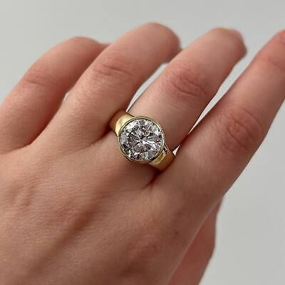 a woman's hand with a gold and diamond ring on her left hand,