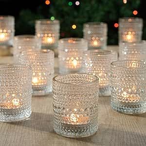 there are many glass cups that have candles in them on the table next to each other