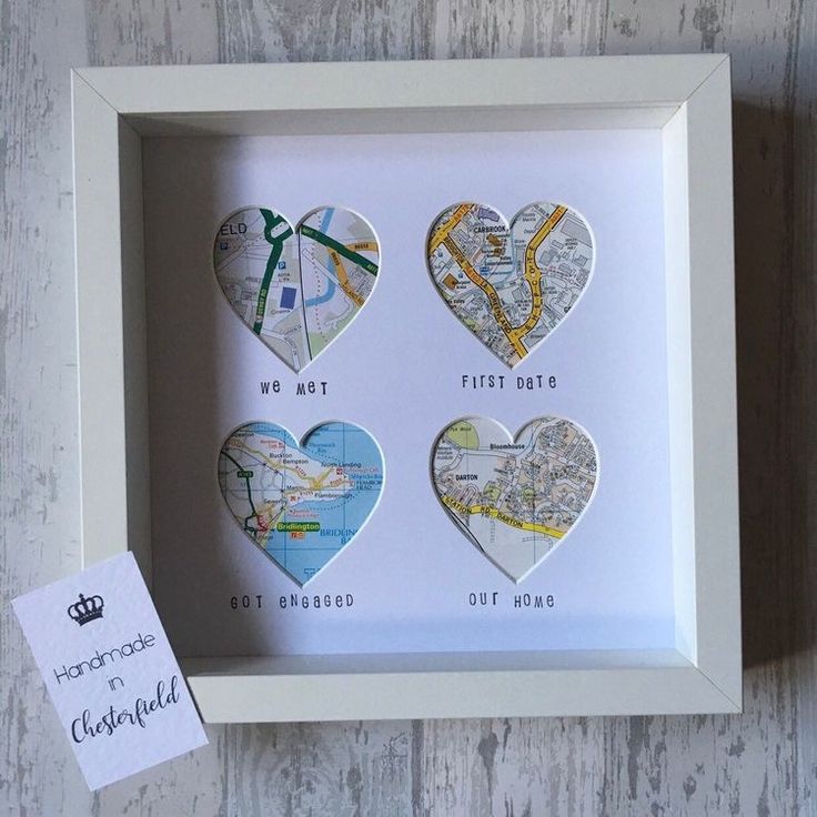 three heart shaped maps are in a white frame with a tag on the wall next to it