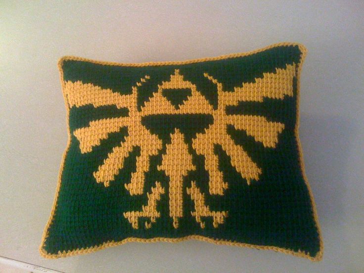 a crocheted pillow with the legend of zelda symbol on it's back