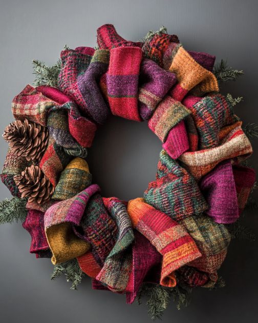 a colorful wreath with pine cones and plaid fabric