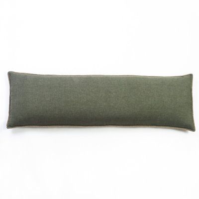 a green pillow on a white surface with a black border around the edges and bottom