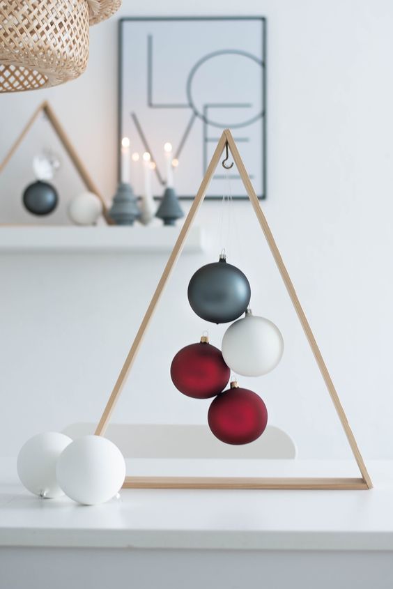 three balls are hanging from the ceiling in front of a shelf with other ornaments on it