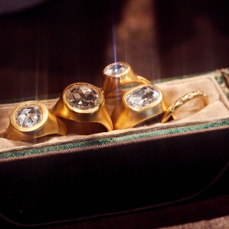 three gold rings sitting in a box on top of a table