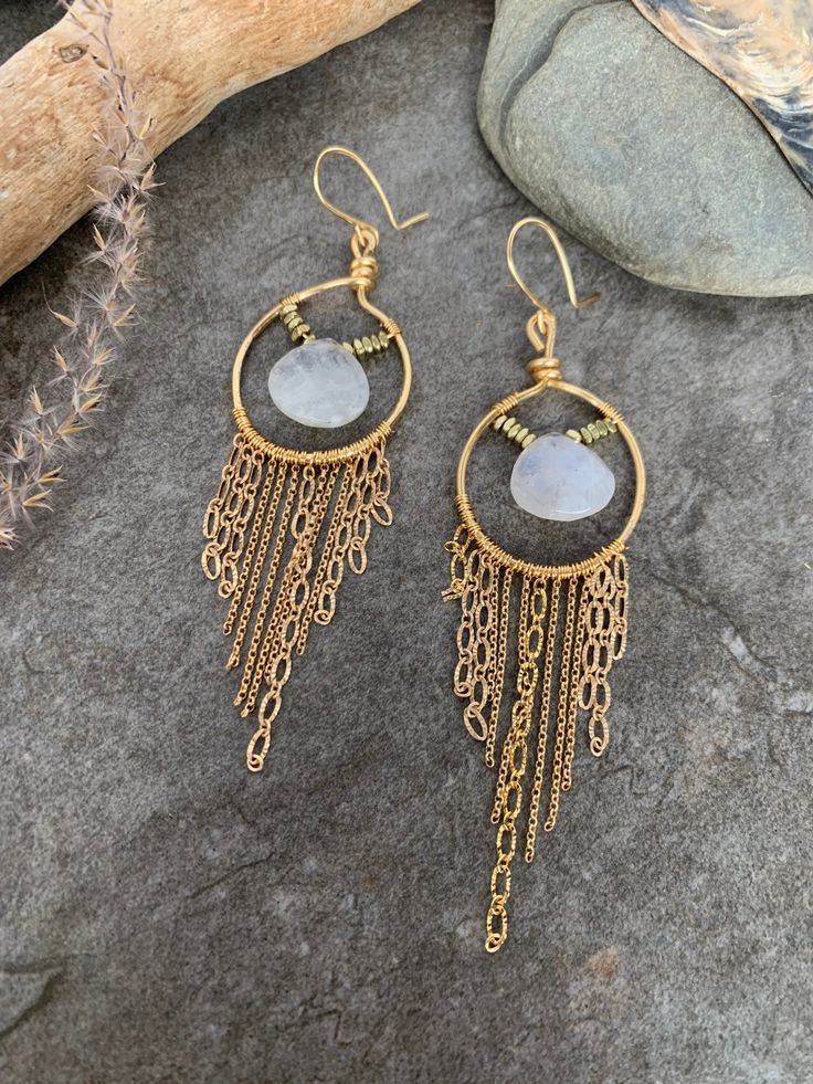 Fun boho style fringe earrings ... crafted with hand forged gold tone hoops with hand wire wrapped dainty gold tone chain accented with elegant Moonstone focal gemstones . These beauties measure 4 inches in length . Wire Wrapped Brass Chandelier Dangle Earrings, Bohemian Gold Hoop Earrings With Dangling Charms, Gold Bohemian Chandelier Earrings With Dangling Beads, Bohemian 14k Gold Filled Wire Wrapped Jewelry, Bohemian Wire Wrapped Long Drop Chandelier Earrings, Handmade Gold Bohemian Tassel Earrings, Gold Moonstone Dangle Hoop Earrings, Bohemian Gold Moonstone Jewelry, Bohemian Hoop Earrings With Dangling Charms