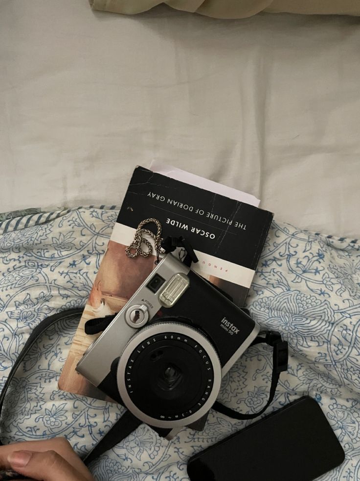 a camera and some books on a bed