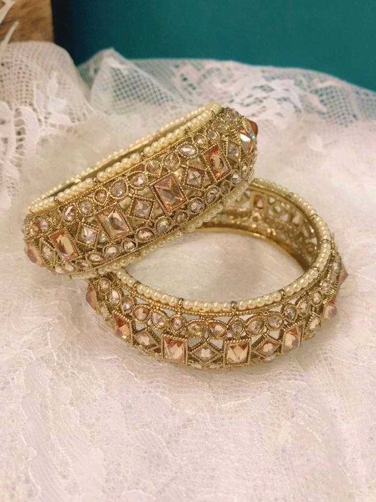 Polki pachili style bangle Shaila in antique gold. Antique based and champagne stone. Pearl lining . About one inch in width. Brass made. Top class polki. One Inch, Antique Gold, Gold Bracelet, Champagne, Bangles, Brass, Stone, Gold