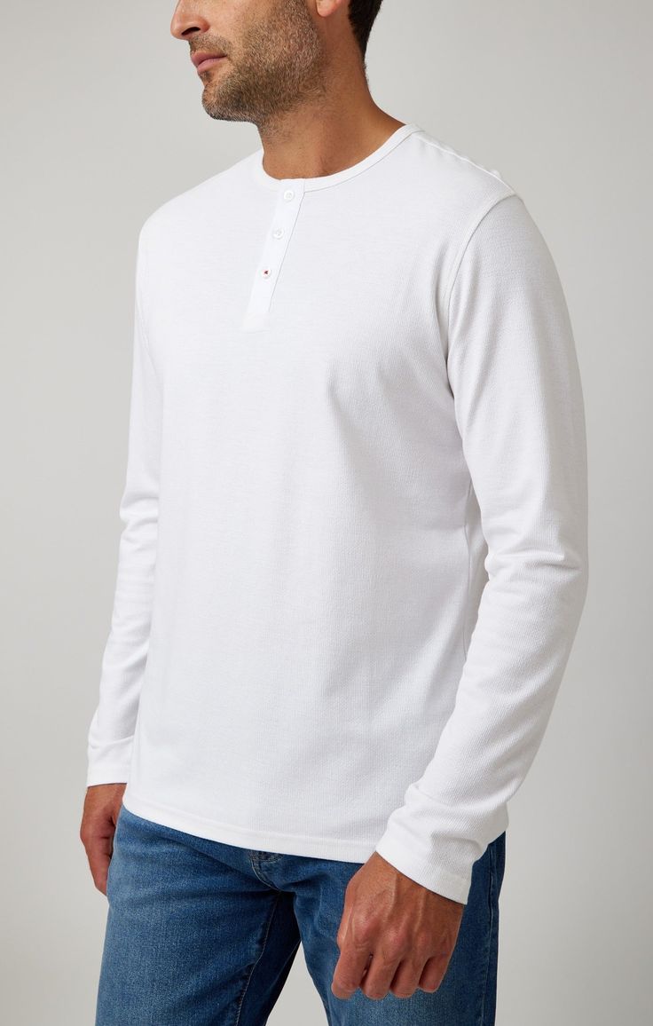 Introducing the White Solid 3 Buttons Henley: A Fusion of Comfort and Style Embrace the perfect blend of casual elegance with our White Solid 3 Buttons Henley. This piece is a staple for any discerning gentleman's wardrobe, offering a balance of timeless style and modern functionality. Our hybrid henleys are a cut above the rest, crafted from a rich cotton blend pique that provides an unparalleled softness. The fabric's slub texture adds a touch of luxury and uniqueness to the garment, making it Mens Wardrobe Essentials, Gentleman's Wardrobe, White Solid, New And Improved, Men's Wardrobe, Sweaters Knitwear, Henley Shirts, Casual Elegance, Modern Man