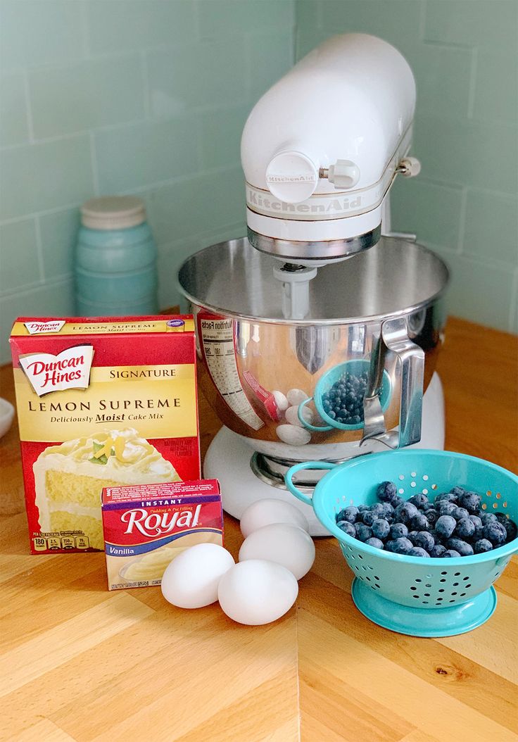 ingredients for blueberry cheesecake sitting on top of a counter next to an electric mixer