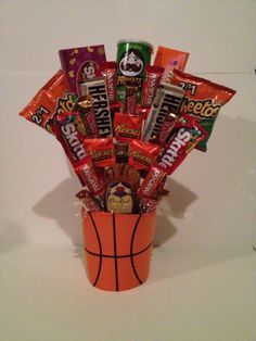 a basket filled with candy and candies on top of a white counter next to a wall