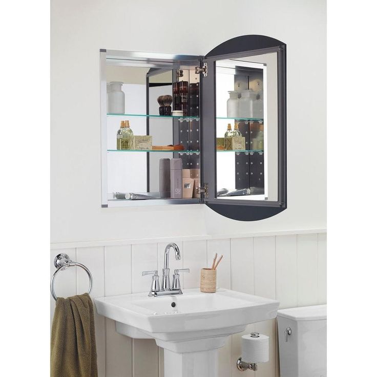 a bathroom sink sitting under a mirror next to a wall mounted medicine cabinet with shelves above it