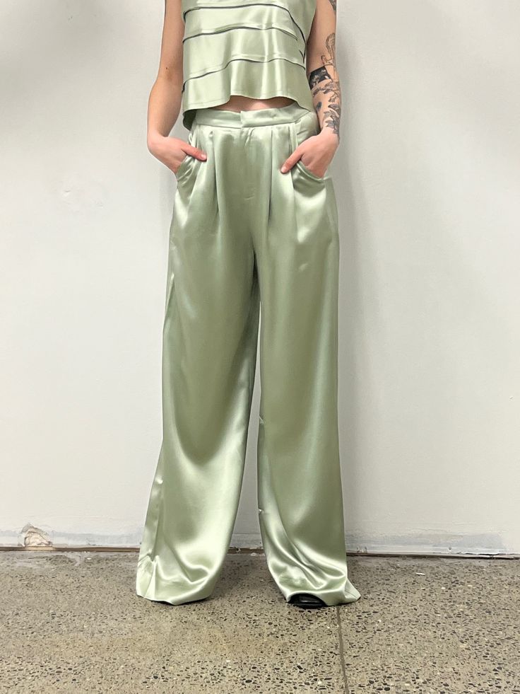 The Paris Pant is a high-waisted, wide-leg pant. Classic & elegant these beautiful pants have a lovely drape with soft front pleats. Love. 100% Triacetate Model is 5'9 and wears a size small Elegant Green Wide Leg Pants With Pockets, Summer Pleated Satin Bottoms, Pleated Satin Bottoms For Summer, Chic Green Satin Bottoms, High Waist Green Bottoms For Evening, Green Wide Leg Pants For Evening, Chic High Waist Culottes For Evening, Chic High-waist Culottes For Evening, Chic High-waist Evening Culottes