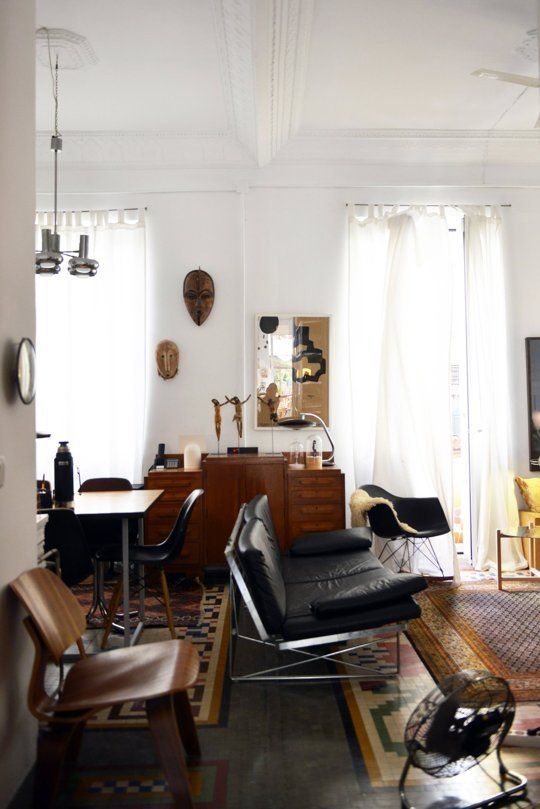 a living room filled with lots of furniture and decor on top of a hard wood floor