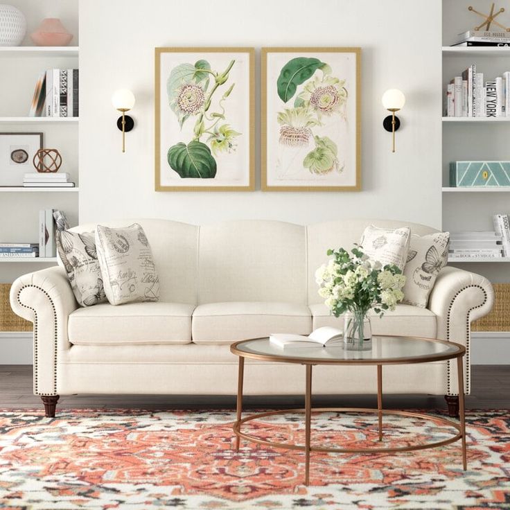 a living room with two paintings on the wall and a coffee table in front of it