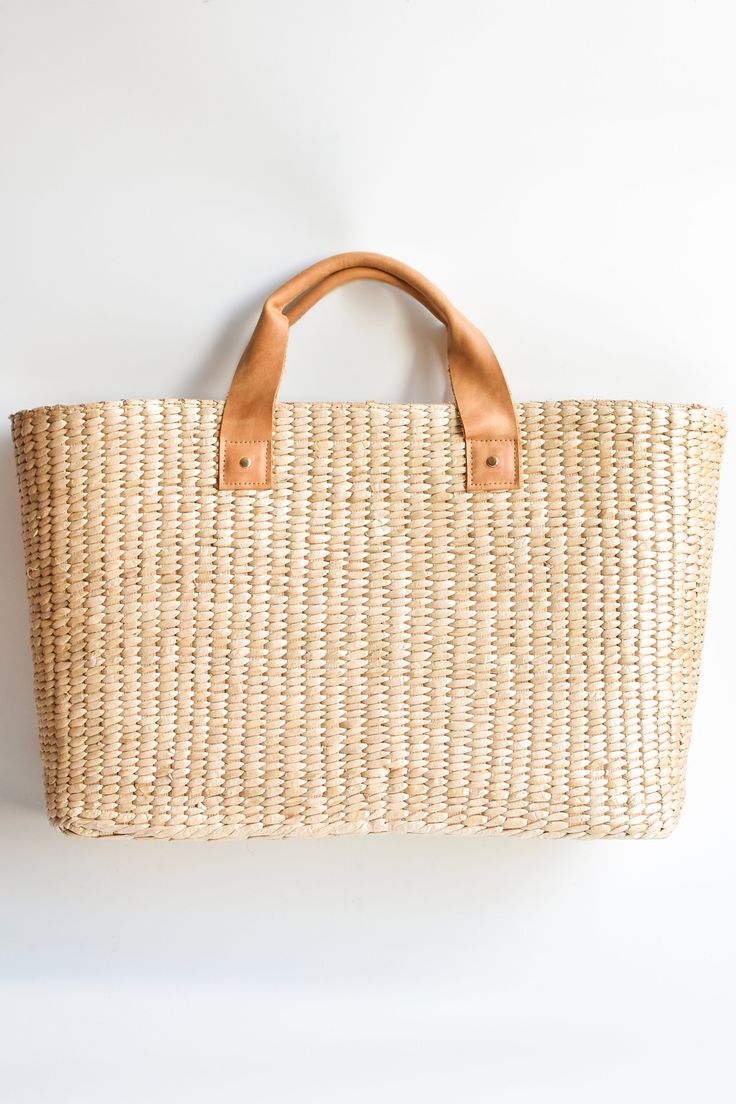 This airy, straw tote bag is finished with natural leather handles and a classic linen lining. Versatile and stylish, it's the perfect partner for airy dresses, summer prints or white denim. Content:- Straw- Leather - Linen Lining- Imported Size:- Width: 18.25" - Height: 12"- Depth: 6.59"- Handle Drop: 4.5" Chic Natural Beach Bag With Handles, Chic Natural Straw Bag With Leather Handles, Chic White Basket Straw Bag, Summer Straw Bag With Rolled Handles For Everyday, Summer Beach Bag With Rolled Handles, Everyday Summer Beach Bag With Rolled Handles, Elegant Beach Bag With Leather Handles For Vacation, Chic Natural Beach Bag With Double Handle, Spring Vacation Beach Bag With Rolled Handles