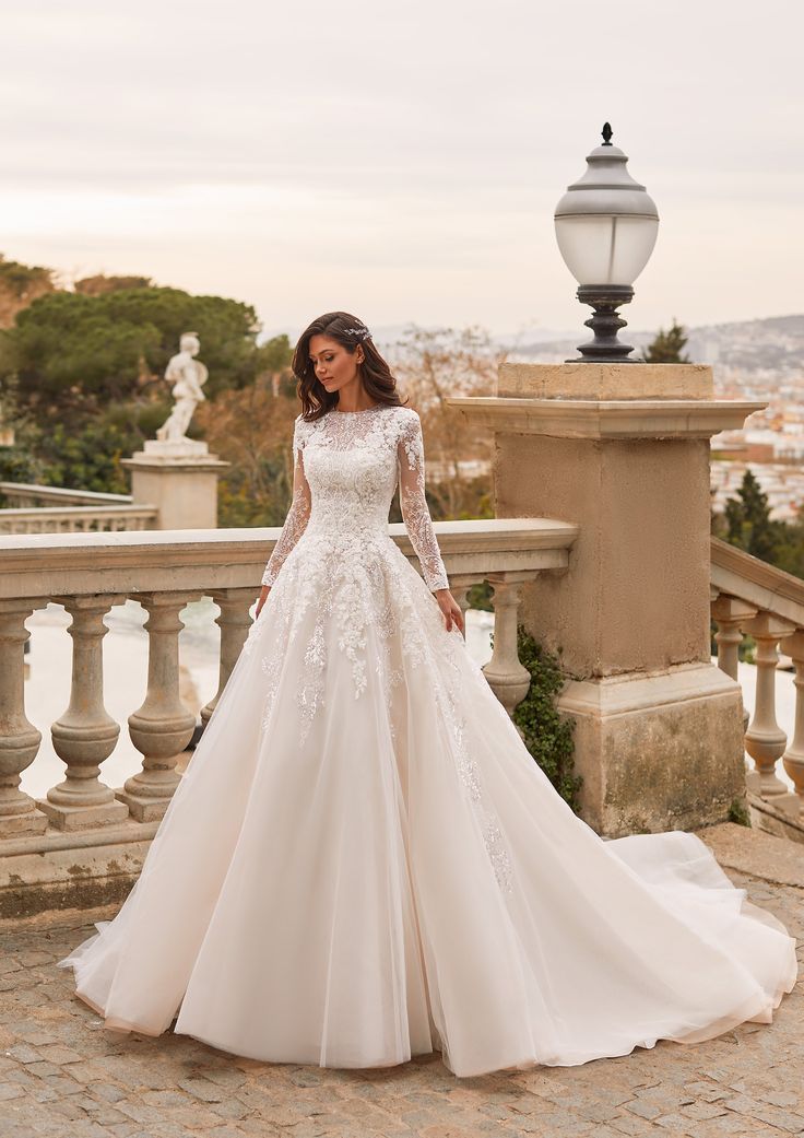 a woman in a wedding dress standing on a balcony