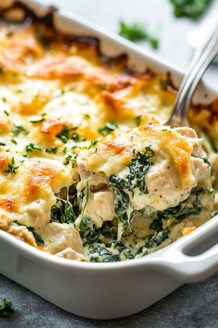 a casserole dish with chicken, spinach and cheese