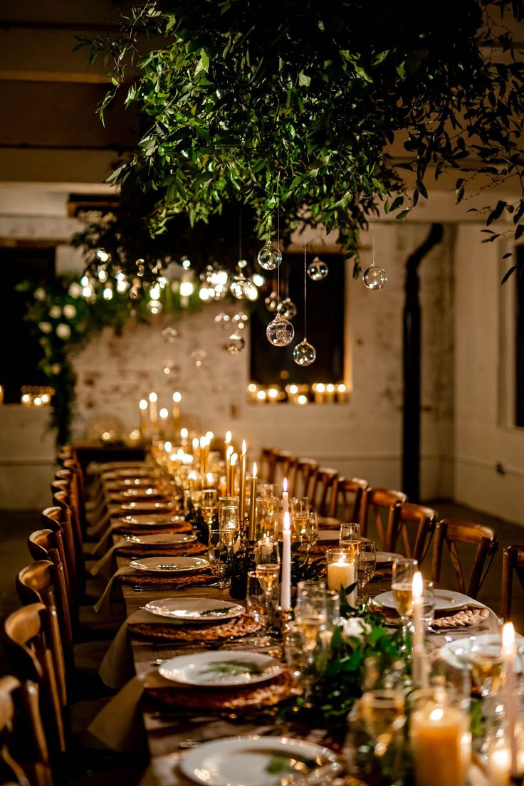 a long table with candles and plates on it