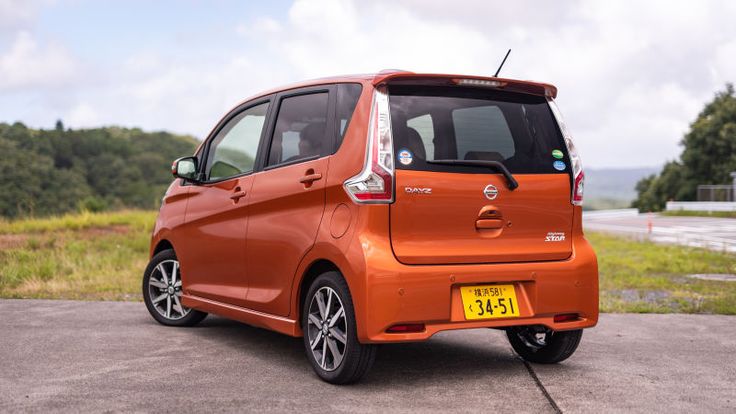 an orange car is parked on the side of the road