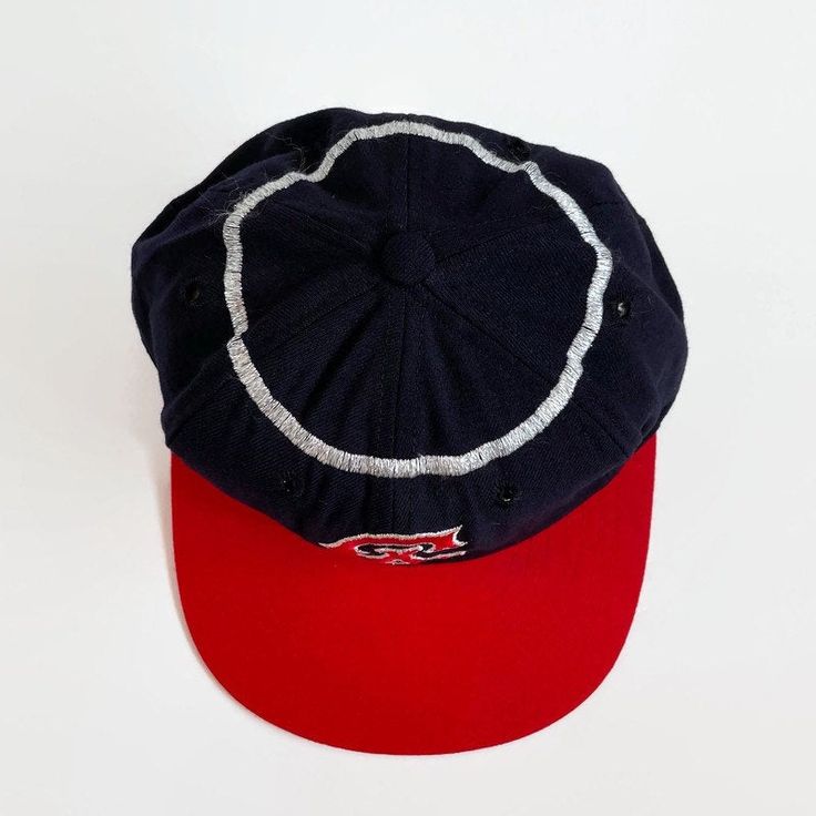 "Here is a rare display item from the \"Golden Age of Baseball\". Offered is an original California Angels KM Pro cap from the 1960s. The cap features the California Angels interlocking \"CA\" logo on the front, red bill and silver halo stitched around the crown. The six-point crown suspension's interior is lined with a leather sweatband that is home to a vintage \"KM Pro\" label. This cap is labeled as a size \"7\". Features - Color: navy, silver and red - Interlocking \"CA\" logo on the front Vintage Baseball Cap For Baseball Season, Retro Six-panel Baseball Cap For Baseball Season, Retro Six-panel Baseball Hat, Vintage Six-panel Baseball Cap For Baseball Season, Retro Six-panel Hat For Baseball Season, Retro Six-panel Fitted Hat For Baseball Season, Vintage Six-panel Trucker Hat For Baseball Season, Retro Six-panel Baseball Cap For Sports, Vintage Baseball Cap With Curved Brim