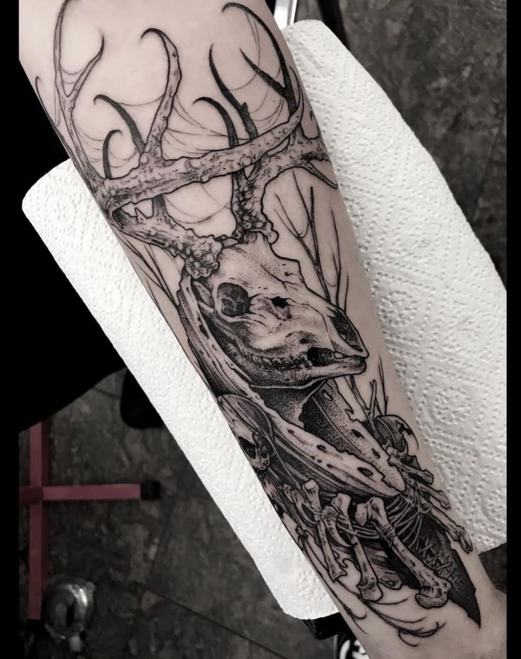 a man's arm with a deer head and antlers on the back of it