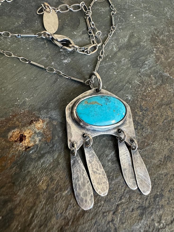 All handmade, one of a kind uniquely handcrafted sterling silver pendant necklace features a gorgeous turquoise cabochon stone (12x20mm / 3mm thick) bezel set in sterling silver. Four sterling teardrops dangle and give movement to this unique southwestern style pendant, handcrafted in my studio. Stamped .925 on the back. It hangs on a rustic 16-18 inch oxidized sterling silver bar & link chain.  *Each handmade ArtAffections Jewelry piece is presented to you hanging on a card within a plastic sleeve and ready wrap up as a gift. PENDANT Gallery: https://www.etsy.com/shop/ArtAffectionsJewelry?ref=seller-platform-mcnav&search_query=Recycled+Chunk+of+Sterling+Silver+Nugget+Pendant+Necklace FEEDBACK: "One of Etsy's best! This seller is phenomenal...worked with me on a special order & was very ac Jewelry Bar, Silver Bar, Southwestern Jewelry, Handcrafted Artisan Jewelry, Stone Pendant Necklace, Southwestern Style, Sterling Silver Necklace Pendants, Silver Bars, Oxidized Sterling Silver