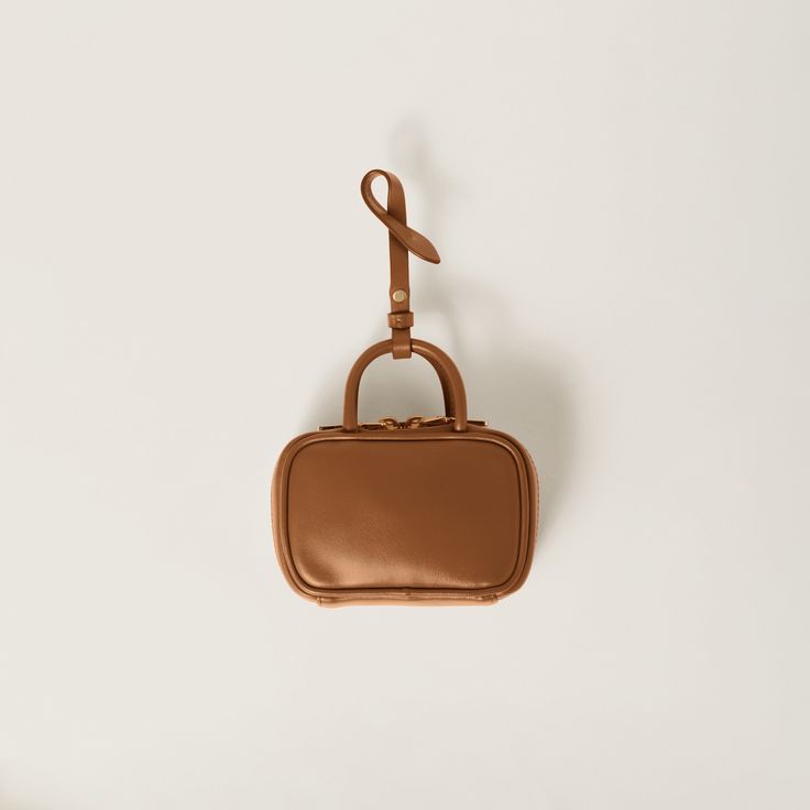 Find MIU MIU Miu Miu Leather Micro Bag on Editorialist. This Miu Miu micro bag is crafted from leather and features a top handle, a detachable leather strap, a zipper closure, an embossed logo, and a cotton satin lining. Cognac Leather Bag With Round Handle, Miu Miu Brown Shoulder Bag For Everyday, Leather Handheld Box Bag, Miu Miu Rectangular Travel Bags, Luxury Brown Miu Miu Shoulder Bag, Miu Miu Brown Leather Shoulder Bag, Brown Leather Miu Miu Shoulder Bag, Miu Miu Shoulder Bag With Adjustable Strap For Travel, Brown Satchel With Round Handle For Travel