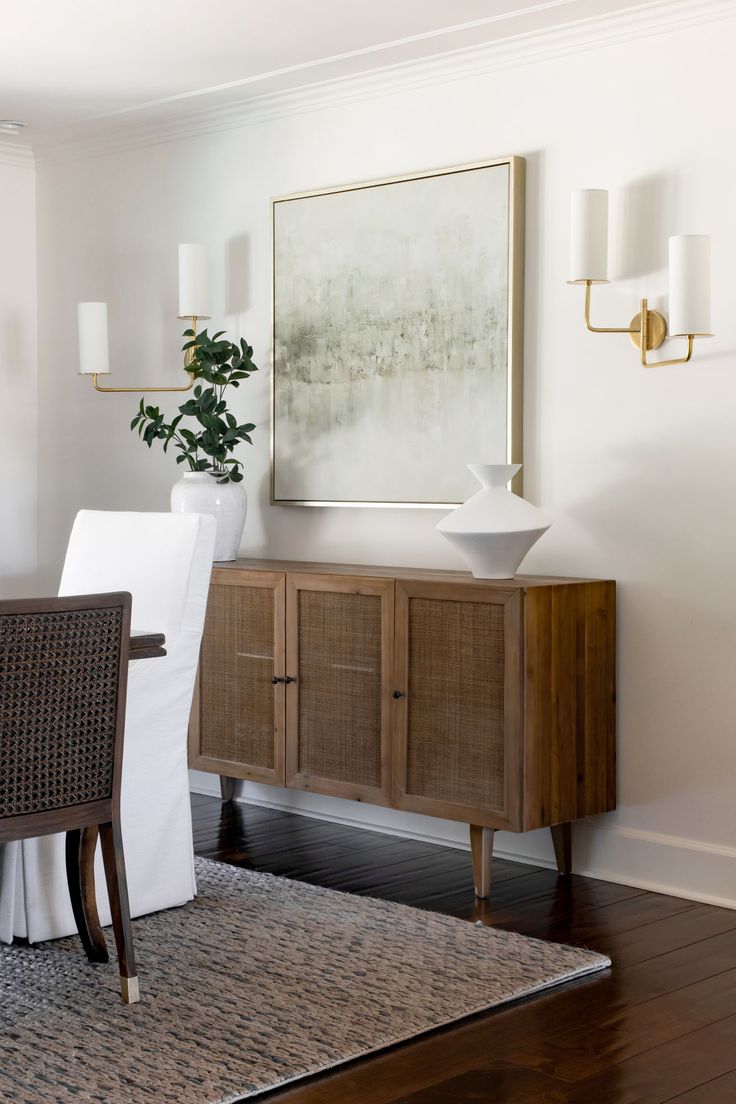 a dining room table and chairs with a painting on the wall behind them in an elegant setting