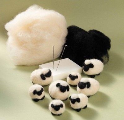 several balls of wool are sitting next to a piece of white material with black spots on it