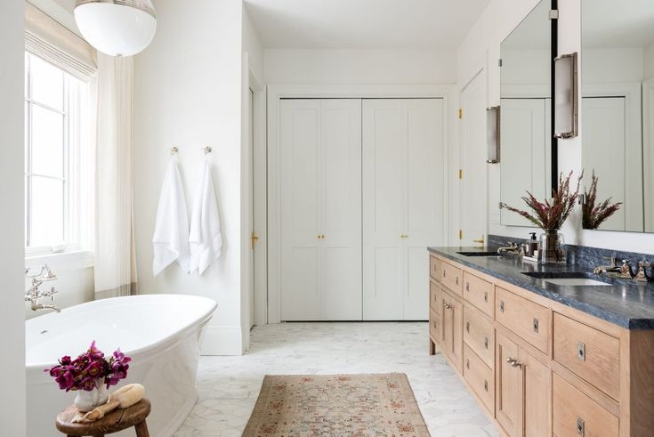 a bath room with a tub a sink and a large mirror on the wall above it