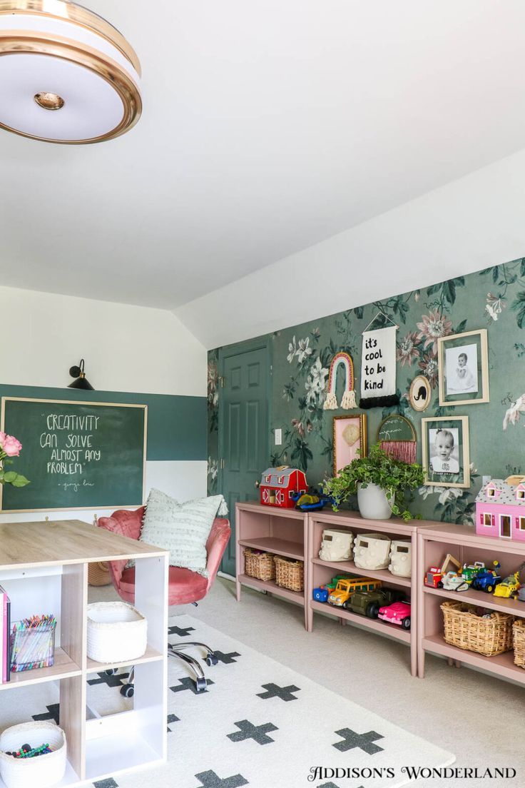 a room filled with lots of pink furniture and pictures hanging on the wall above it