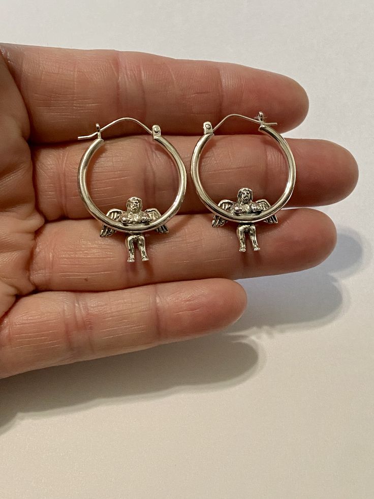 "ITEM: Sterling Silver Angel Hoop Earrings ( I made these from a 1980's Vintage mold) COMPOSITION: Sterling Silver CONDITION: New WEIGHT: 5.74 Grams MEASUREMENT: Hoop with Angel - 1 3/8\" Long x 1\"Wide MARKS: 925" Vintage Hoop Clip-on Earrings For Gift, Vintage Clip-on Hoop Earrings For Gift, Vintage Hoop Earrings With Ear Wire, Vintage Round Hoop Earrings With Ear Wire, Vintage Clip-on Hoop Earrings As Gift, Vintage Nickel-free Hoop Earrings, Vintage Sterling Silver Dangle Hoop Earrings, Sterling Silver Clip-on Hoop Earrings As Gift, Vintage Hoop Earrings For Gifts