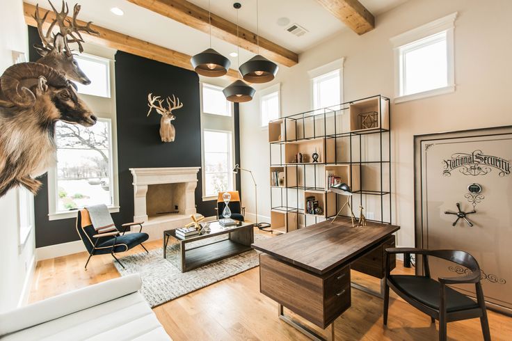 a living room filled with furniture and a deer head mounted to the wall over a fireplace