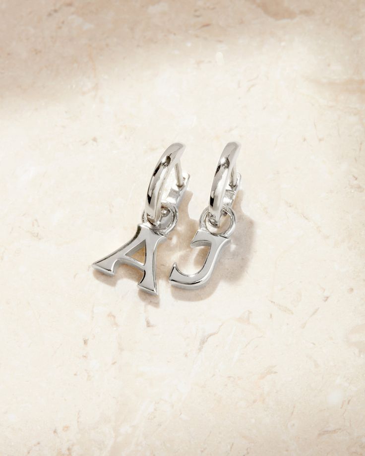 Meet the Luv Aj Fine Plain Metal Hoops featuring a custom initial charm. Available in Sterling Silver or 14K Gold, this classic piece is perfect to customize for yourself or a gift for a friend. This pair of earrings is available in two fonts to really make it your own xx Classic Sterling Silver Initials Jewelry, Classic Sterling Silver Jewelry With Initials, Timeless Sterling Silver Jewelry With Initials, Personalized Classic Silver Earrings, Sterling Silver Initials Earrings, Classic Engraved White Gold Earrings, Elegant Sterling Silver Initial Earrings, Personalized Elegant Huggie Earrings, Elegant Personalized Sterling Silver Earrings