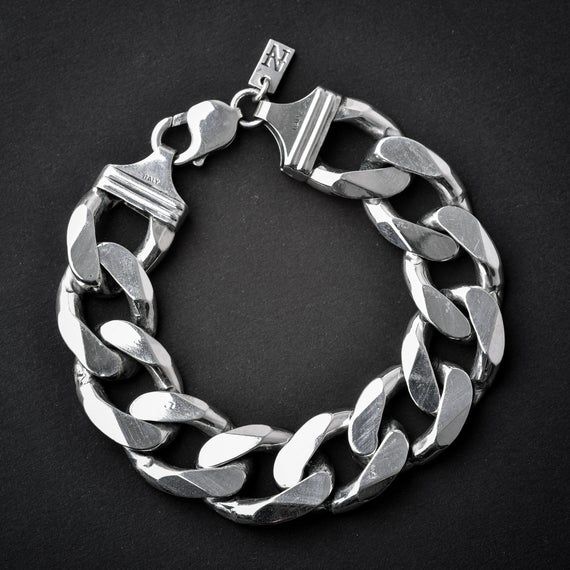 A handmade sterling silver 925 massive and heavy chain link bracelet.Each bracelet is cleaned and polished with care.The weight of the bracelet may vary according to size.Approx. weight: 97grChain link witdh: Approx. 18mmChain link thickness: Approx. 5.6mmThe bracelet is made of sterling silver 925 and is water resistant.All of our chain link products go through the same process. Full oxidization, cleaning and polishing/brushing. The oxidization (blackening) is left in the cracks and in between Silver Polished Cuban Link Bracelet, Modern Silver Cuban Link Bracelet With Chunky Chain, Silver Cuban Link Bracelet With Chunky Chain, Silver Link Bracelet With Chunky Chain, Sterling Silver Chunky Chain Bracelet With Rectangular Links, Classic Silver Cuban Link Bracelet With Chunky Chain, Modern Chunky Silver Bracelet, Silver Bracelets With Chunky Oval Link Chain, Silver Oval Link Chunky Chain Bracelet