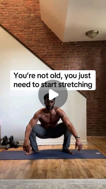 a man is doing yoga in front of a brick wall, with the caption you're not old, you just need to start stretching