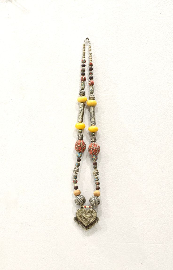 This is a beautiful Vintage Handmade Nepal Silver Heart Pendant Necklace with Silver Tubes and Beaded Beads, Resin and Wood Beads with a hook and eye clasp. This necklace is a real show stopper and can be worn on any occasion, or make a wonderful gift and even cool enough to hang on a wall. NOT REAL SILVER Necklace Length 35 Inches Pendant Silver Alloy 3 Inches Long x 2.5 Inches Wide Large Silver Beads 25mm-28mm Round Tubes48 Inches Long x 12mm Wide Small Beaded Beads 9mm-12mm Round AT BACARA WE Real Silver Necklace, Silver Beaded Necklace, Cowrie Shell Necklace, Beaded Beads, Silver Bead Necklace, Silver Heart Pendant, Pendant Silver, Cord Necklace, Shell Necklaces