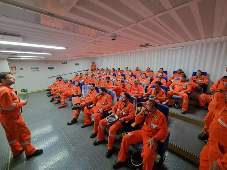 a group of men in orange uniforms sitting next to each other