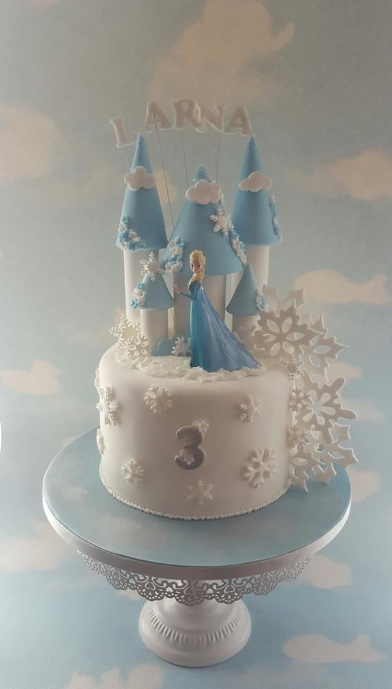 there is a cake that has been decorated with snowflakes and princesses on it