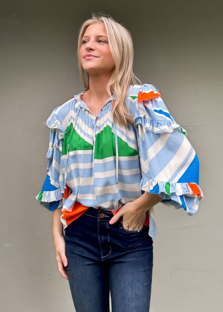 Upgrade your summer wardrobe with our Multi Geometric Ruffle Sleeve Top from Karlie. Featuring a fun and vibrant print, this top will add a touch of playfulness to your outfit. Made for the season, its lightweight fabric will keep you cool and stylish. True to size Olivia is 5'7 wearing small Color: Cream, Blue, Green, and Orange Ruffle Detail Button detail at neckline with ties Not lined 100% Rayon Fabric will shrink in washer - Dry Clean Recommended Playful Summer Blouse With Ruffles, Playful Ruffle Sleeve Tops For Spring, Playful Ruffled Blouse For Summer, Playful Floral Print Blouse For Spring, Multicolor Ruffled Tops For Day Out, Spring Ruffled Tops For Day Out, Spring Beach Blouse With Abstract Print, Chic Multicolor Abstract Print Blouse, Multicolor Ruffle Sleeve Tops For Vacation