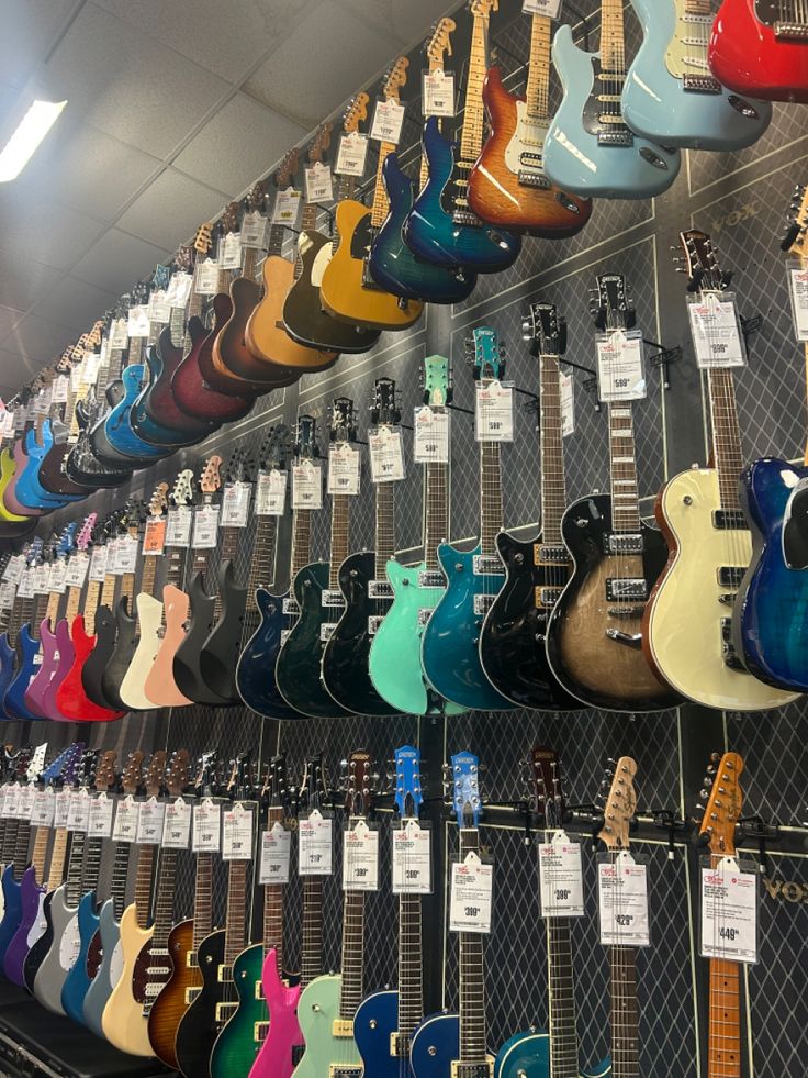 many guitars are on display in a store