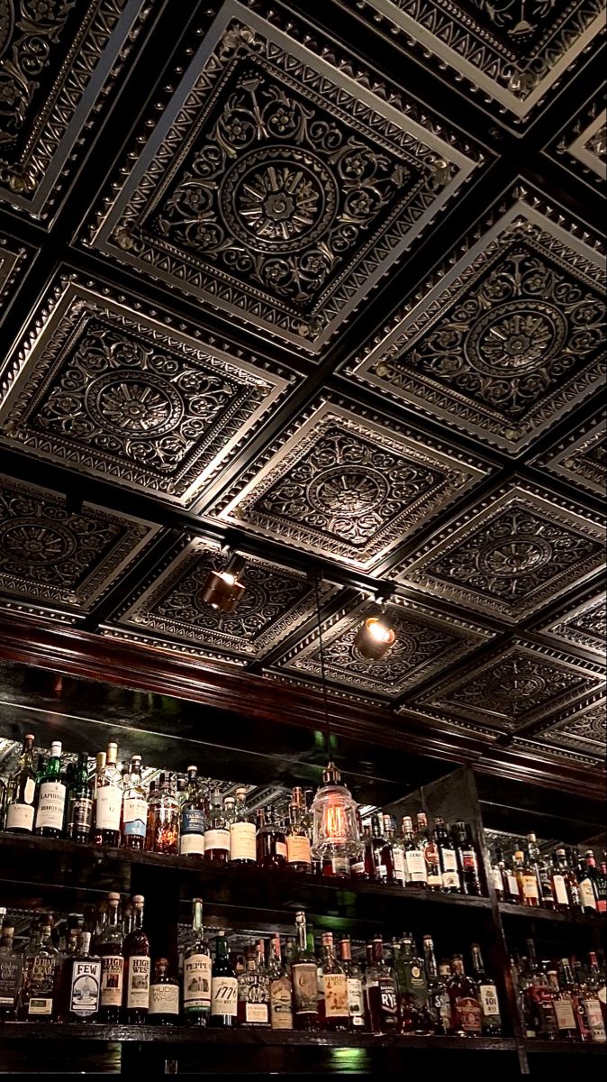 an ornate ceiling in a bar with liquor bottles