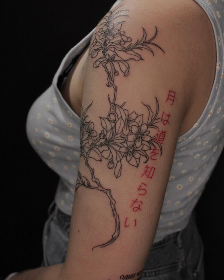 a woman with a tattoo on her arm has flowers and words written in red ink