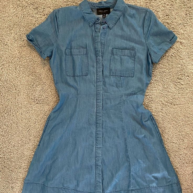 Nwot - Never Worn Beautiful A-Line Silhouette Denim Dress! Button Up Front With Denim Flap Covering The Buttons. Has 2 Side Pockets! Super Soft Material. Size M 100% Lyocell Approximate Measurements: Waist 28” Length ~33” Comment Any Questions And Feel Free To Make An Offer! Medium Wash Cotton Dress With Buttoned Pockets, Spring Denim Blue Dresses With Buttoned Pockets, Medium Wash Summer Dress With Buttoned Pockets, Spring Denim Blue Dress With Buttoned Pockets, Short Sleeve Chambray Dresses With Pockets, Chambray Short Sleeve Dress With Pockets, Denim Blue Cotton Dresses With Buttoned Pockets, Blue Cotton Denim Dress With Buttoned Pockets, Denim Blue Cotton Dress With Buttons