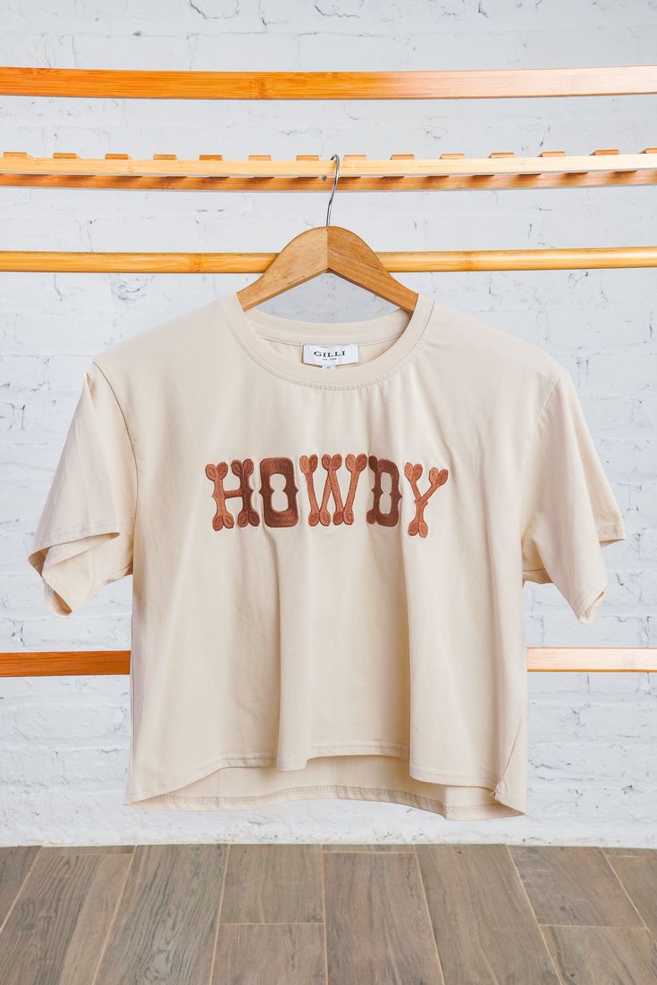 Howdy cream tee Trendy Brown Relaxed Fit T-shirt, Brown Short Sleeve T-shirt With Letter Print, Casual Brown Shirt With Letter Print, Sporty Brown Cotton Tops, Brown Short Sleeve Tops With Letter Print, Brown Relaxed Fit Tops With Text Print, Brown Crew Neck Top With Letter Print, Brown Letter Print Top For Summer, Beige Short Sleeve Top With Letter Print