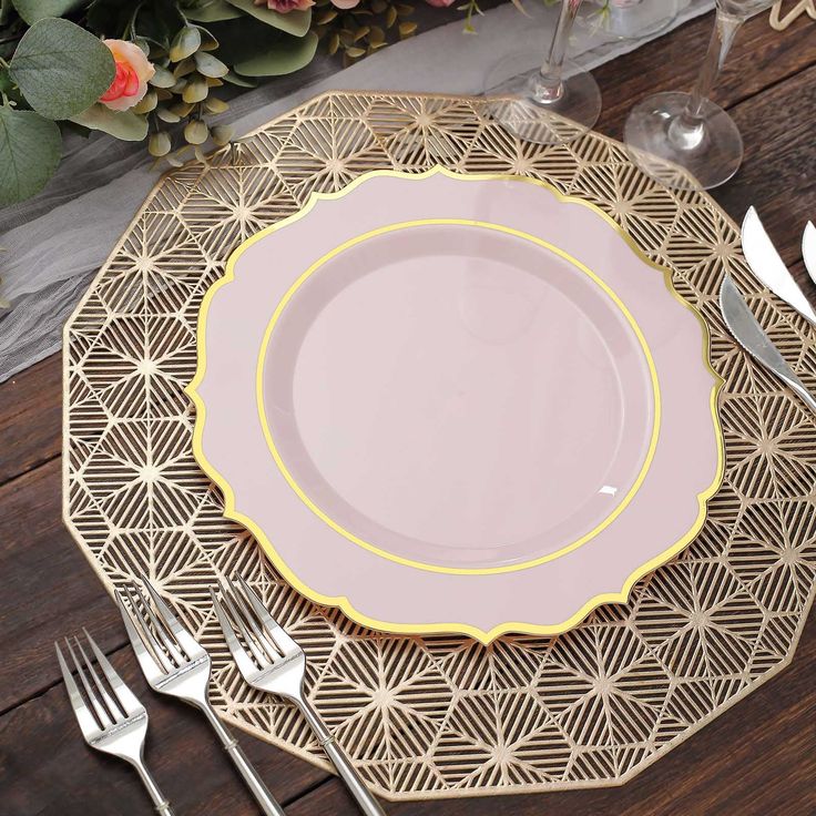 a table setting with pink and gold plates