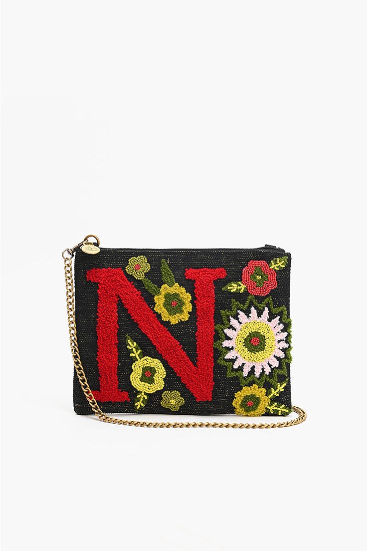 N embellished hand beaded crossbody clutch offers versatility with its adjustable crossbody strap, enabling you to wear it as a shoulder bag or crossbody for hands-free convenience. The strap can be easily detached, giving you the option to carry it as a classic clutch - perfect for both day and night occasions. Top Zip Clutch Embroidery in Front with Letter N Lined Interiors Detachable Chain Strap Top Zip Closure Size: 10" X 7.5" Handmade by artisans in India Chic Beaded Crossbody Shoulder Bag, Spring Crossbody Clutch With Adjustable Strap, Everyday Beaded Crossbody Clutch, Trendy Beaded Crossbody Shoulder Bag, Beaded Crossbody Clutch, Crossbody Evening Bag With Removable Pouch, Spring Crossbody Shoulder Bag With Zipper Pouch, Everyday Beaded Crossbody Shoulder Bag, Beaded Crossbody Shoulder Bag For Travel